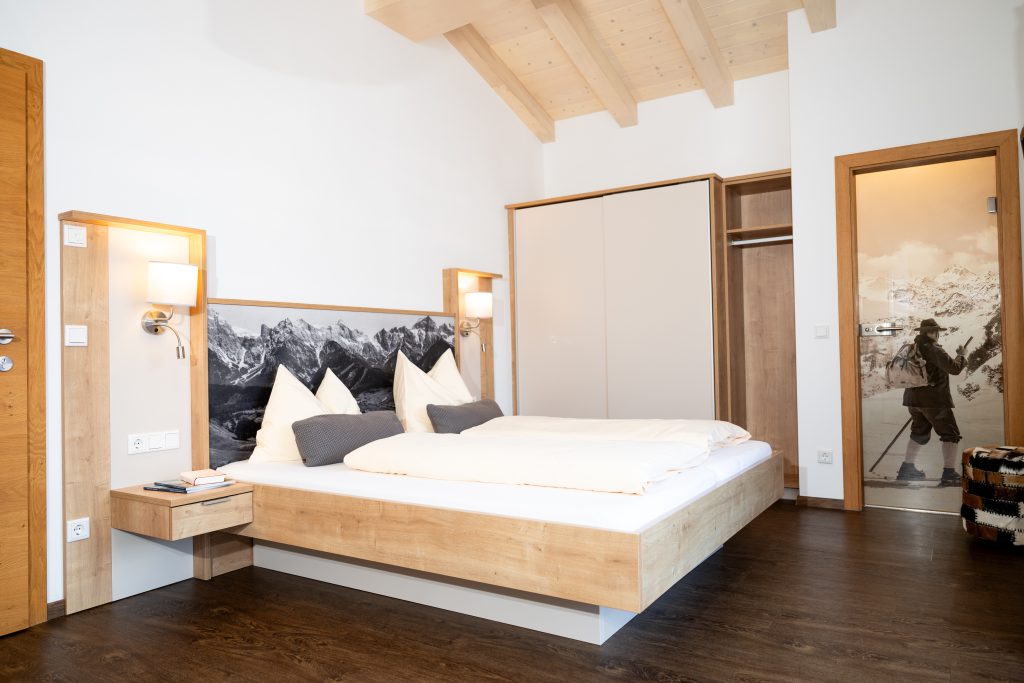 Cozy Room with Double Bed, Wooden Furniture, and Balcony View of the Mountains in Maria Alm