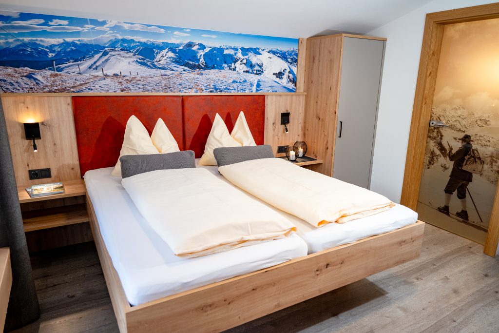 Cozy Room with Double Bed, Wooden Furniture, and Balcony View of the Mountains in Maria Alm