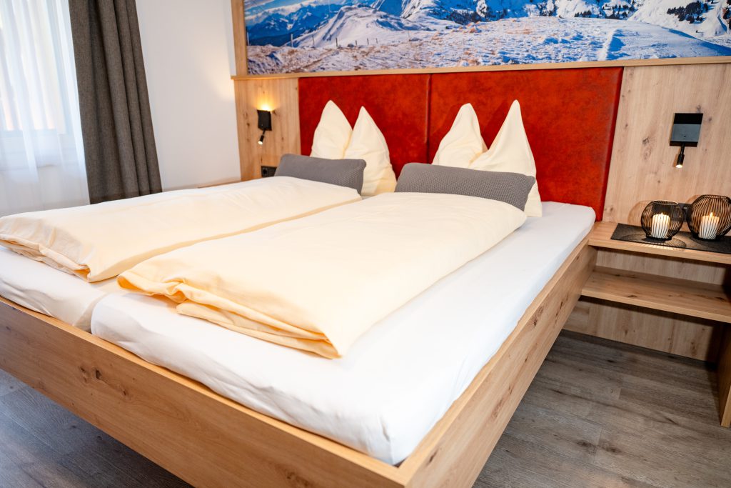 Cozy Room with Double Bed, Wooden Furniture, and Balcony View of the Mountains in Maria Alm